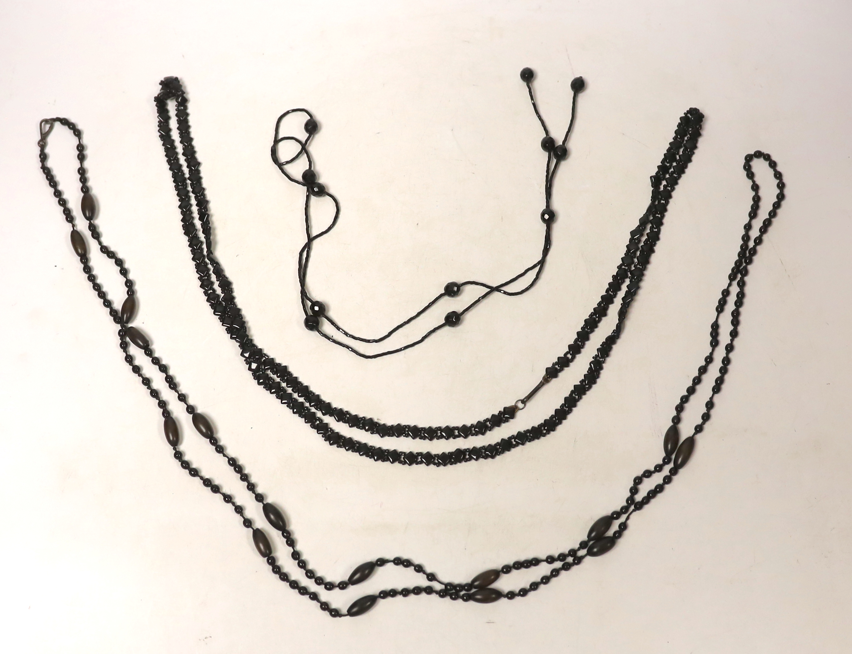 Three assorted necklaces including Whitby jet, largest 162cm.